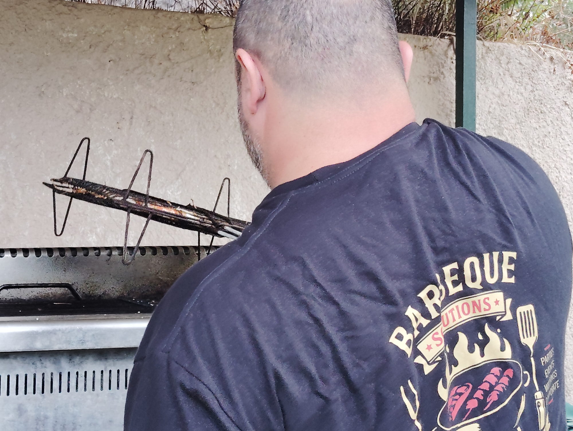Ο σεφ της Barbeque Solutions Corfu στη ψησταριά με τη branded μπλούζα