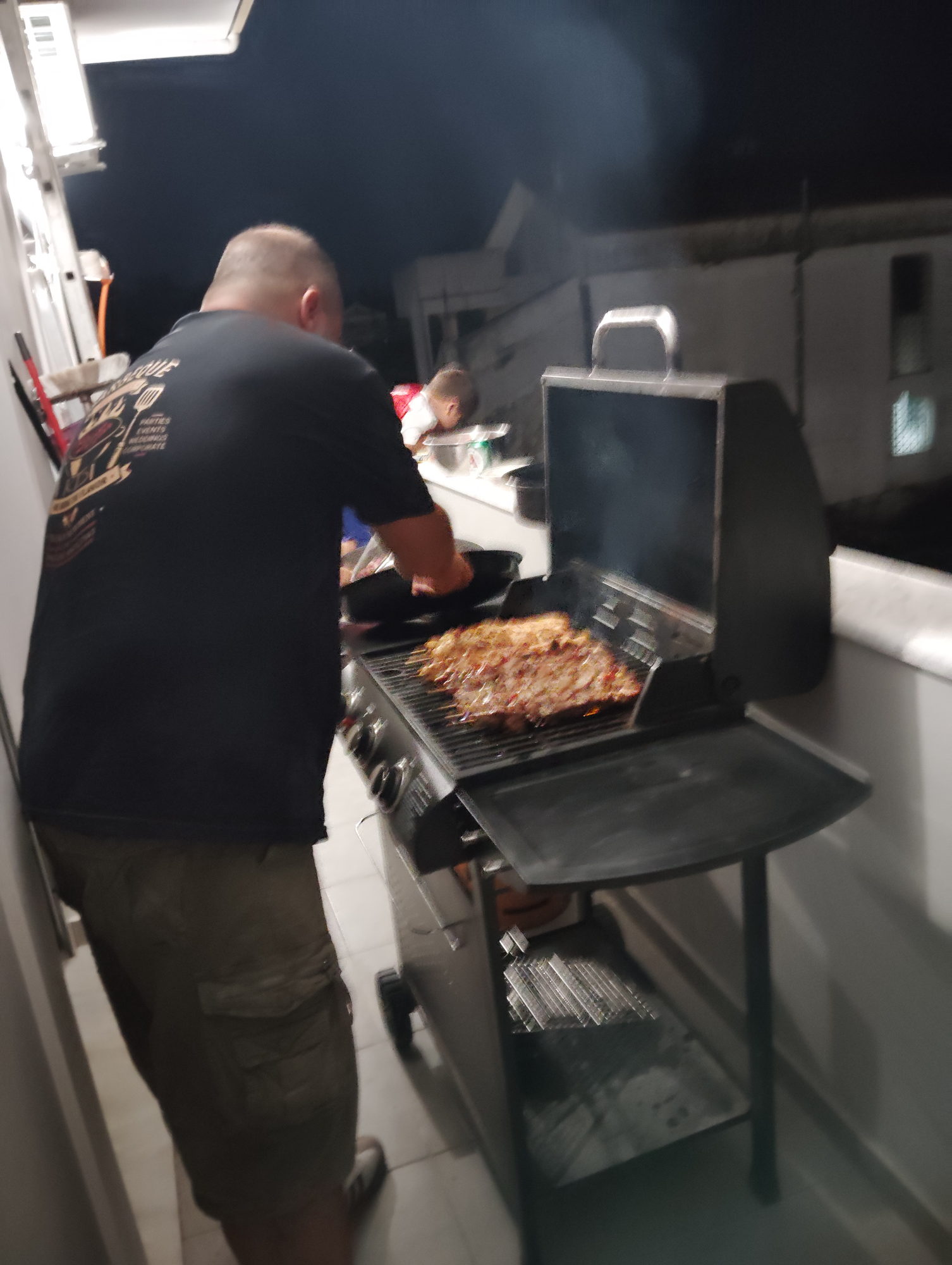 Βραδινό BBQ σε εξέλιξη, ο σεφ σερβίρει ψητό κρέας δίπλα στη ψησταριά